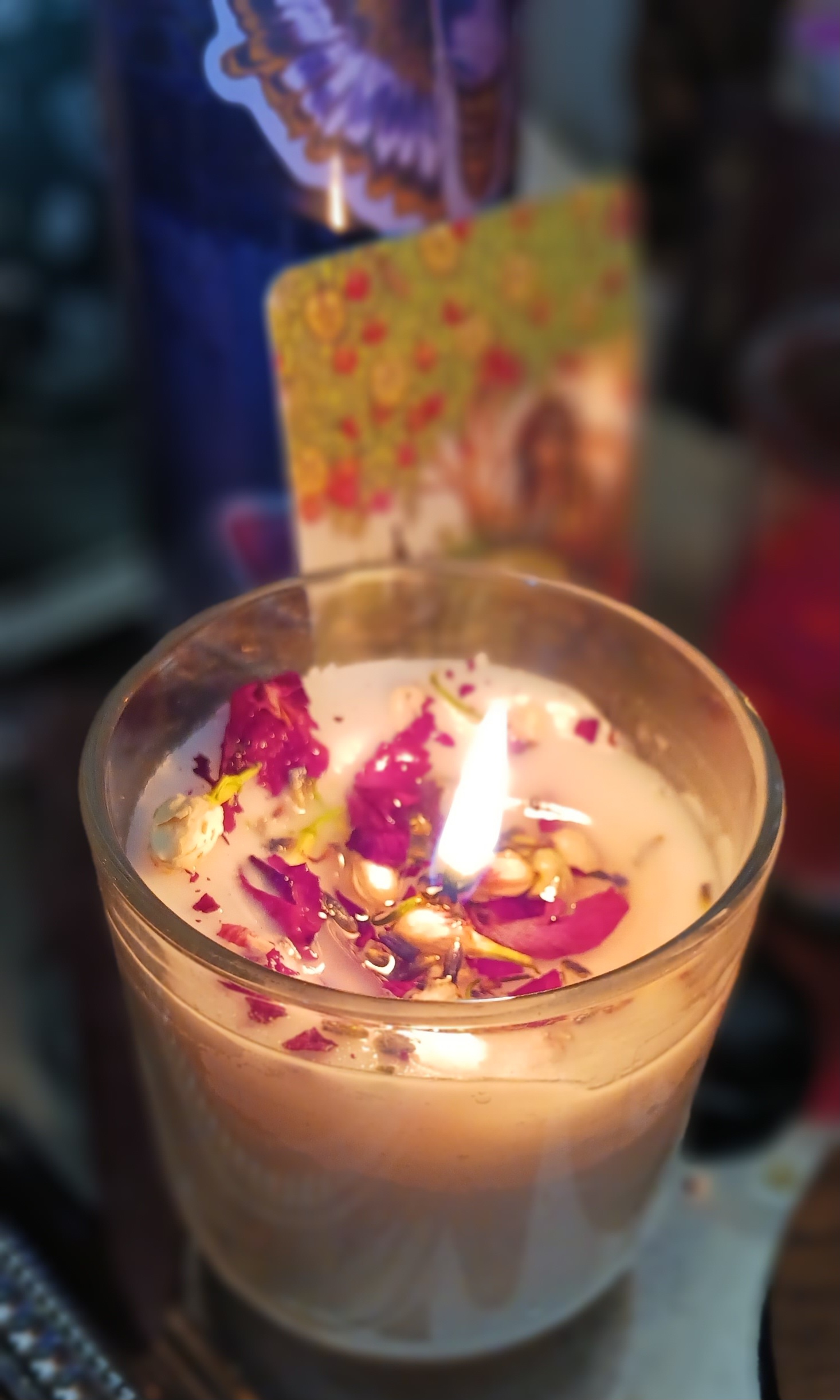 A candle decorated with herbs for a self-love spell.